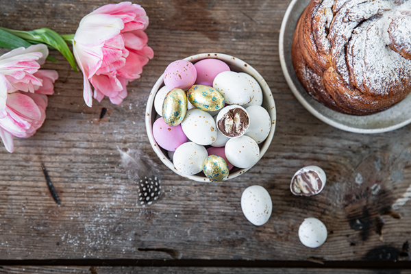 A croissant, eggs, and flowers arranged on a table