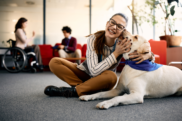 A woman wearing glasses petting a dog