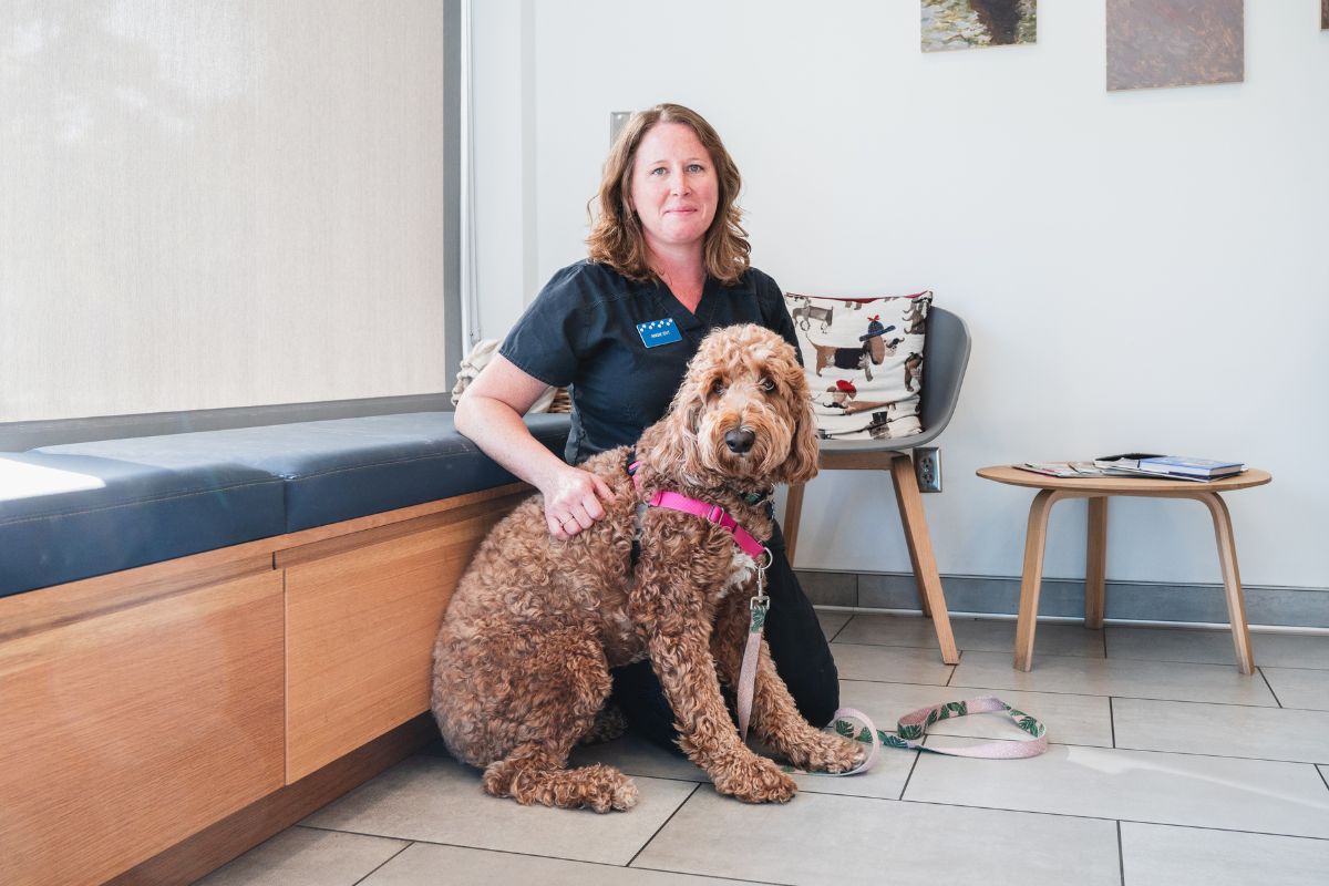 A woman sitting on the floor with a dog